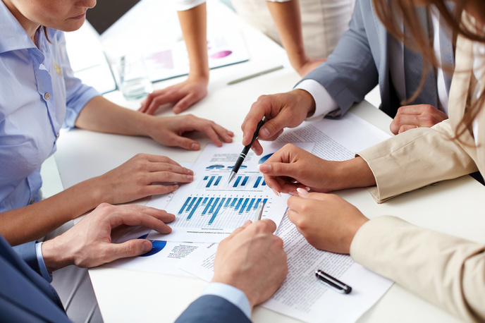 Profissionais analisando gráficos financeiros